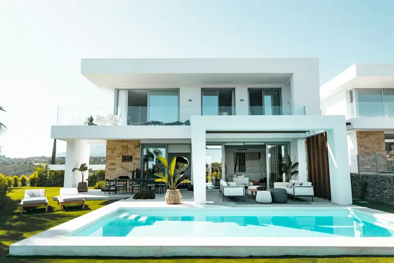 A modern villa and swimming pool, with a grid showing 100 equal investment shares